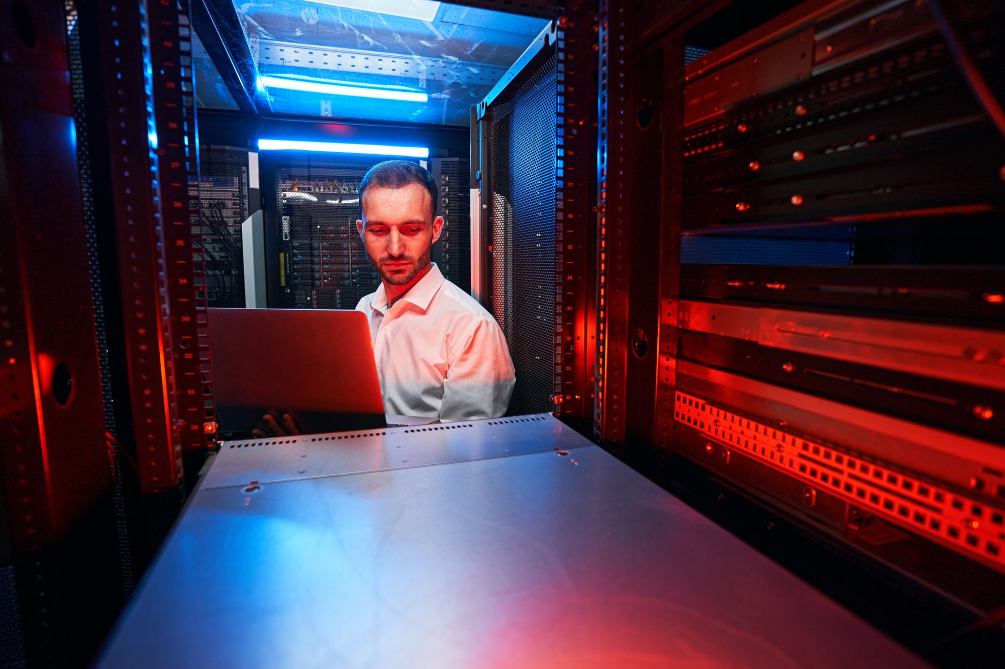 Caucasian IT technician doing security check of server rack