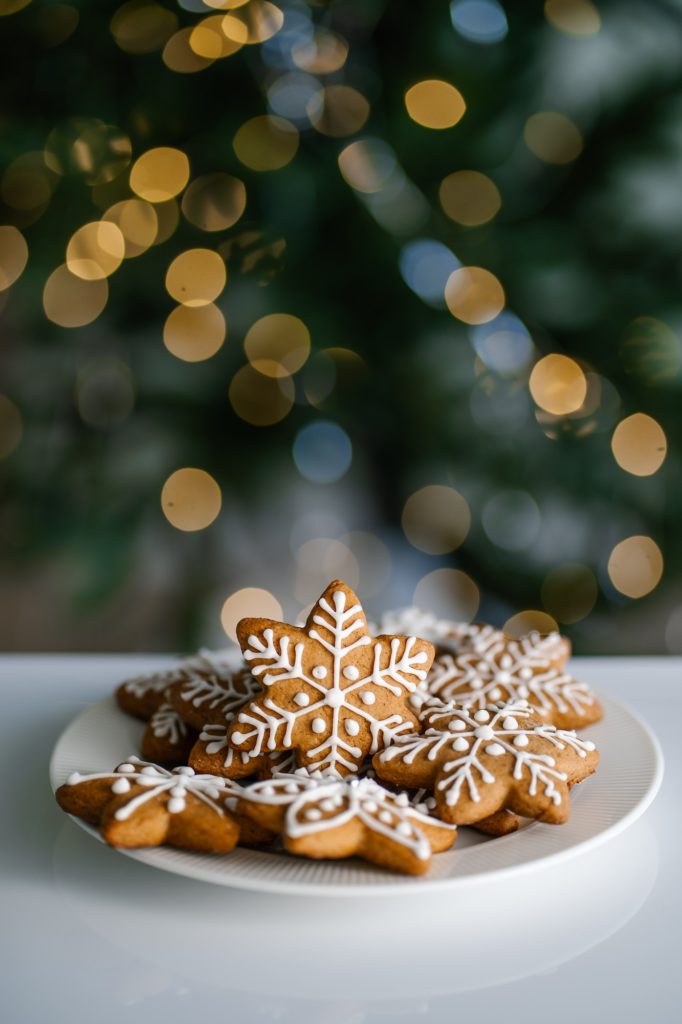 Ginger Christmas cookies on the background of a Christmas tree with lights.