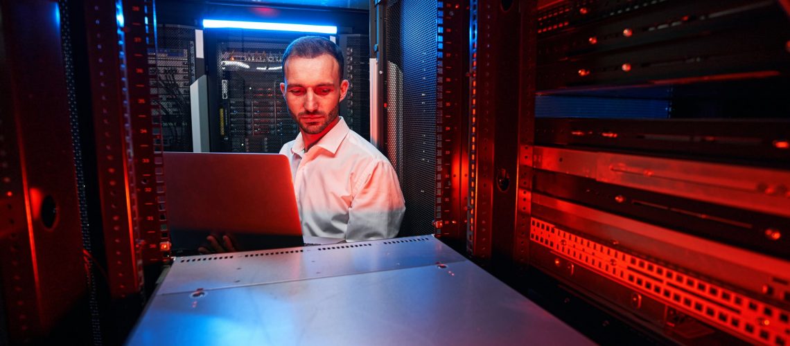 Caucasian IT technician doing security check of server rack